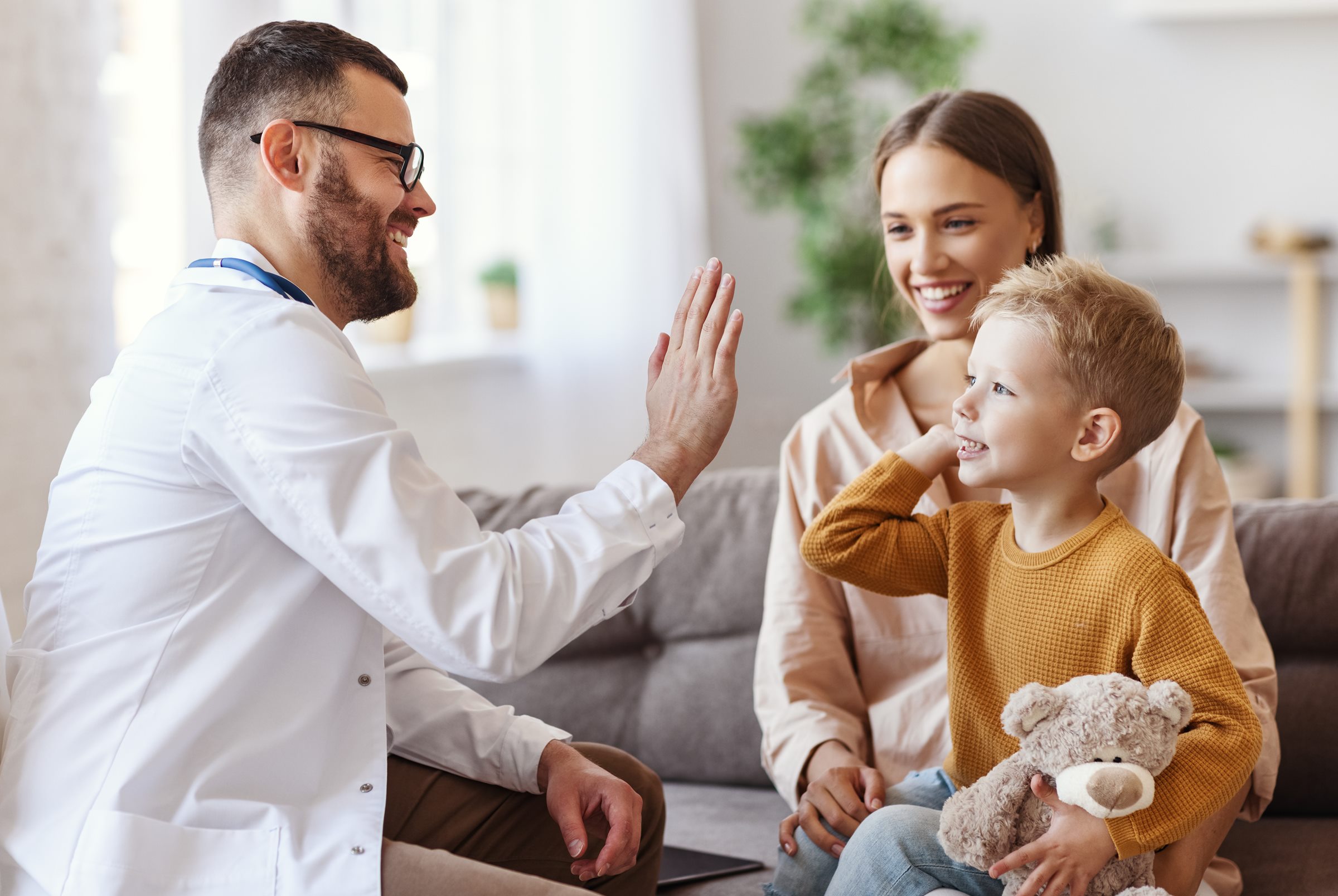 A GP and a young patient sharing a high five